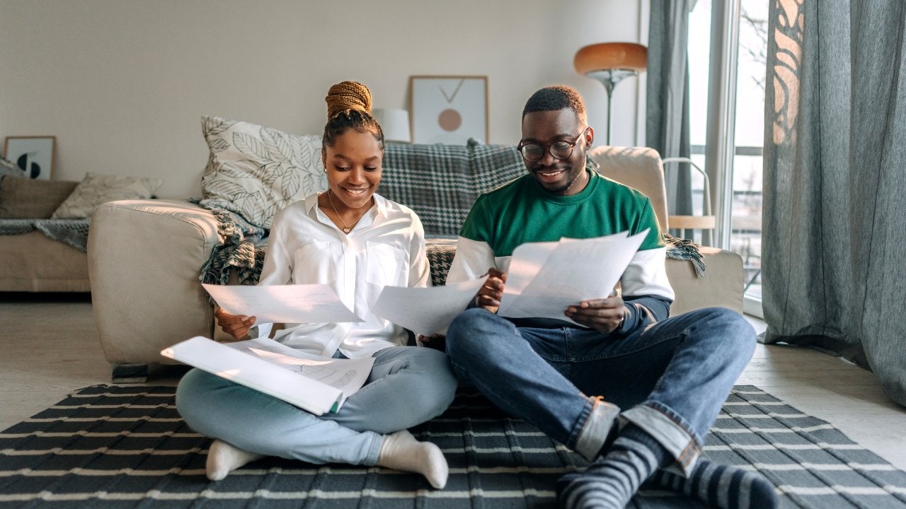 Young smiling couple going over bills