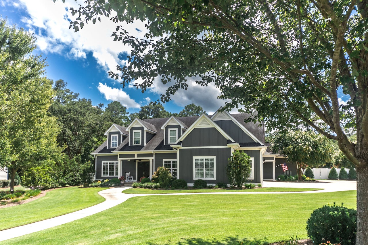 large gray craftsman style home with big lawn