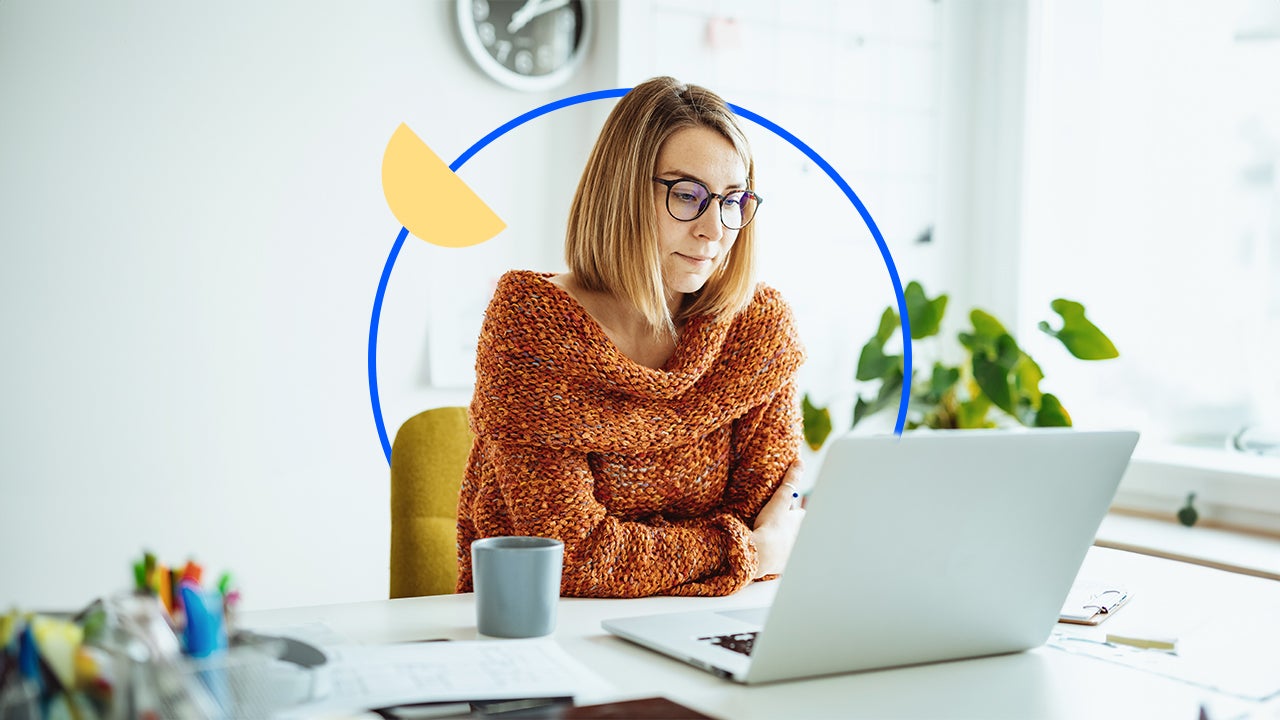 Woman with glasses sitting in front of a laptop.