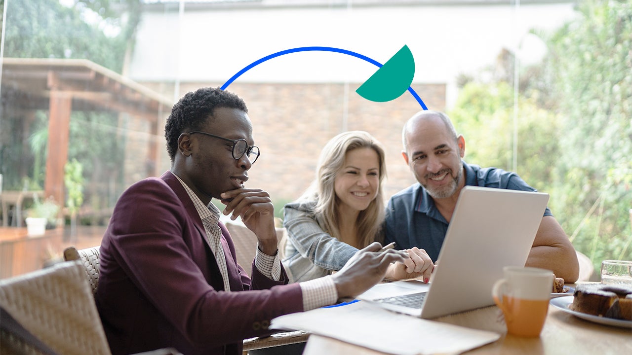 Agent talking with a couple in front of a laptop