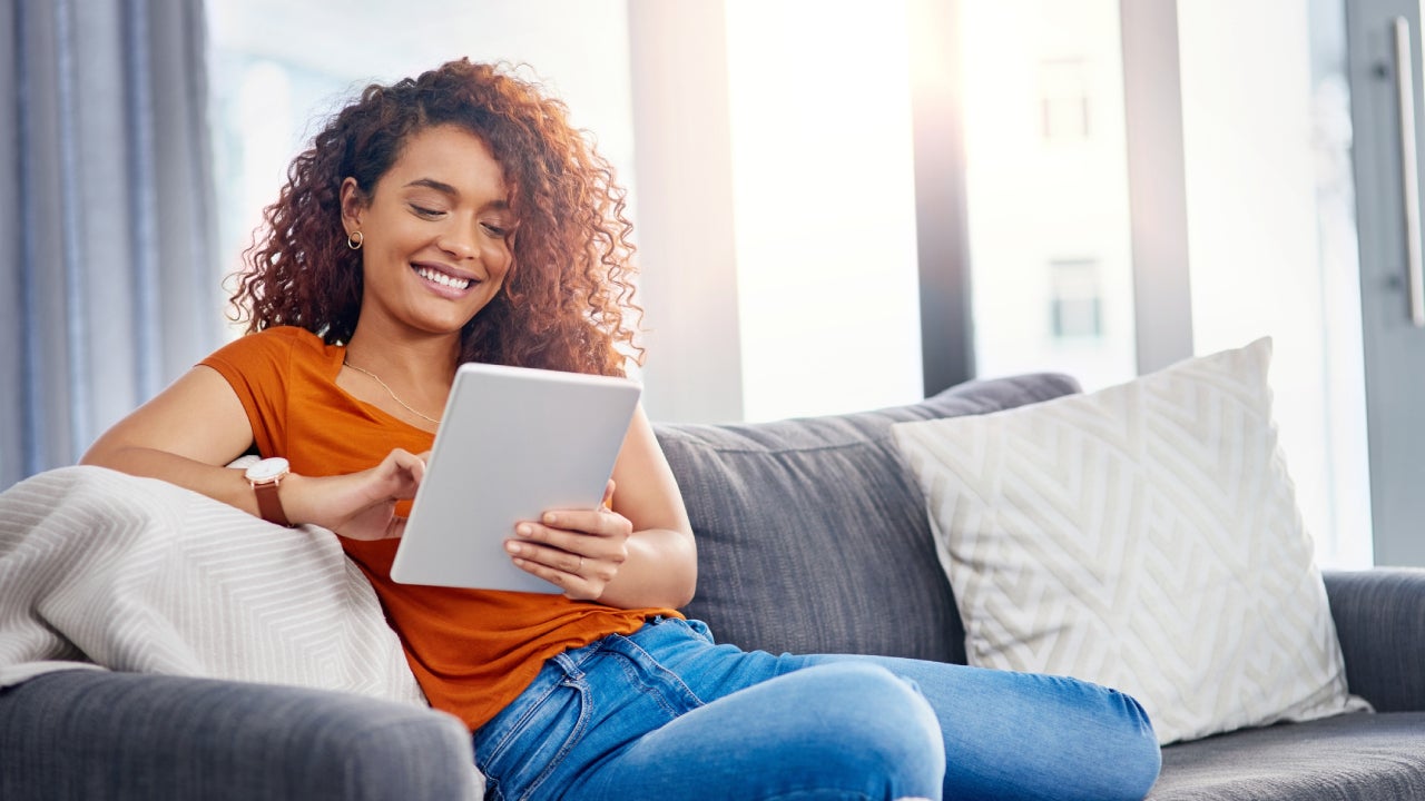 young woman using a digital tablet on the sofa at home