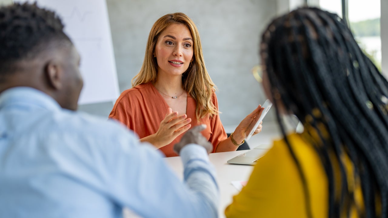 Young businesswoman giving financial advice to couple