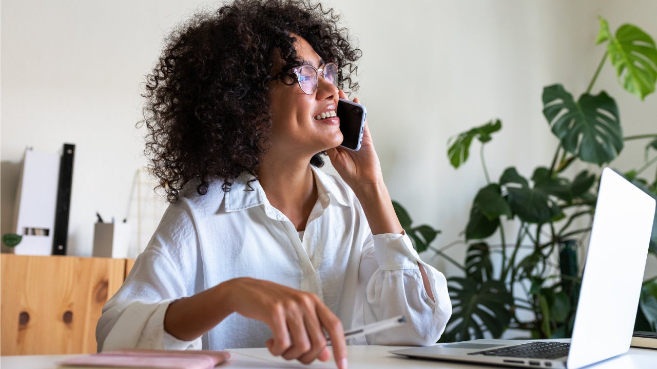 business woman working at home office talking on the phone with client