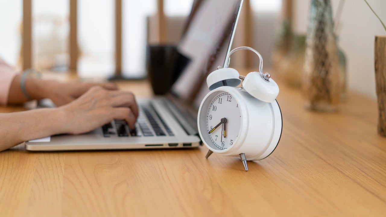 alarm clock on the desk and the laptop