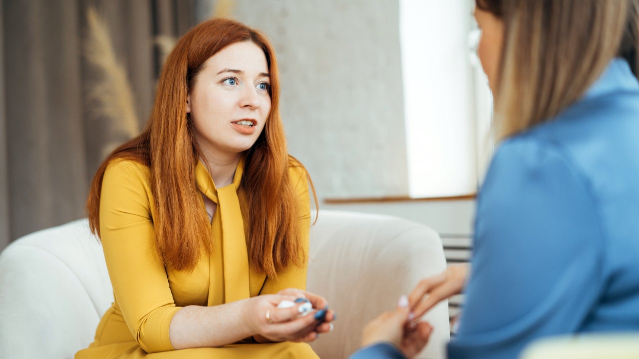 Two women in armchairs are sitting and talking