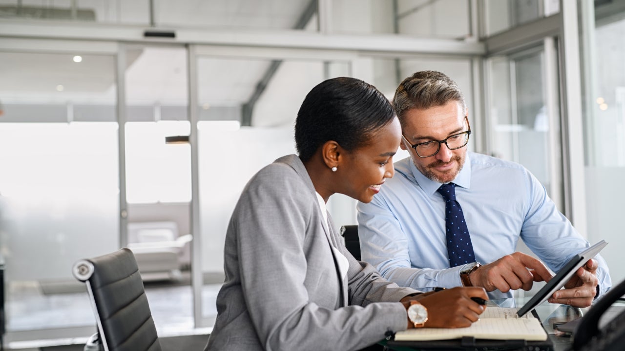 Business partners working on digital tablet in modern office