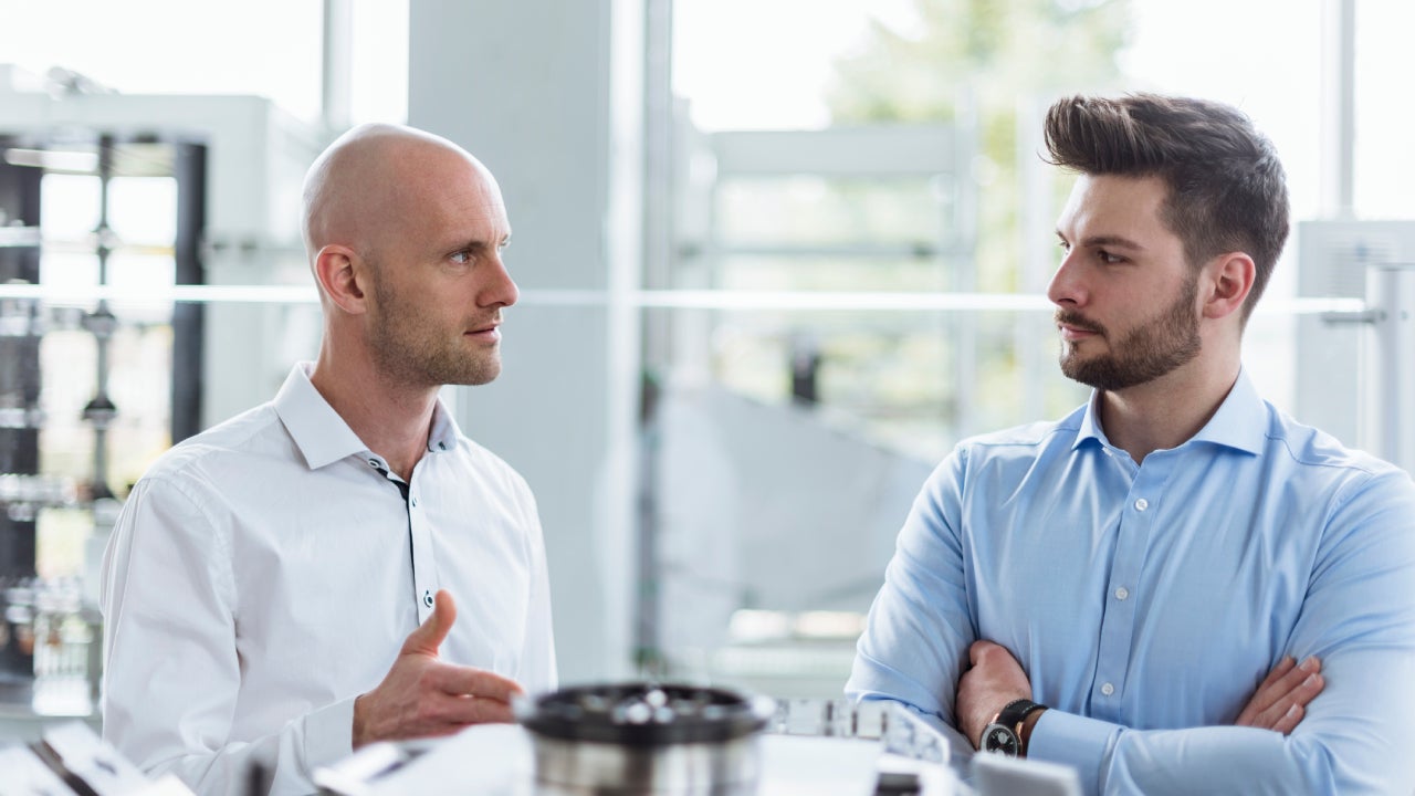 Two men discussing product in company