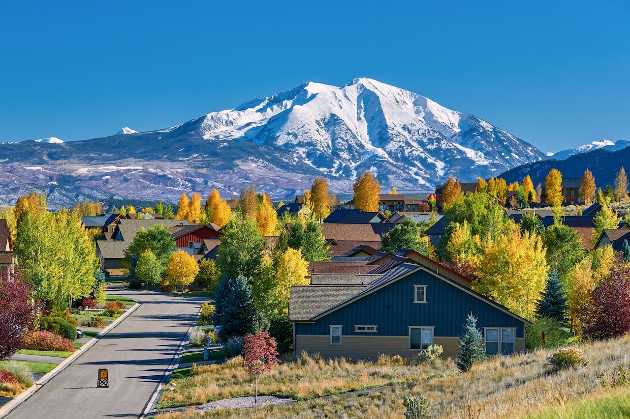 homes in colorado with mountains in distance and fall leaves