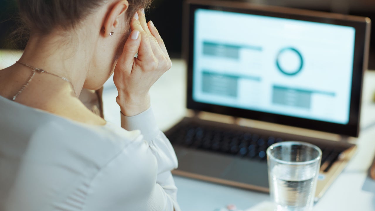 Seen from behind modern business woman having headache