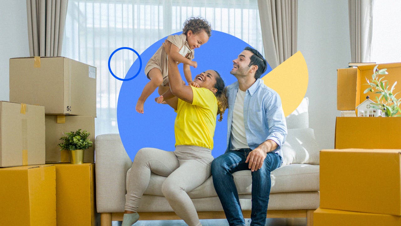 Photo of a family sitting on a couch, the mom lifting a baby