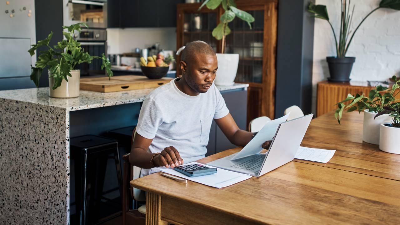 Businessman in his home with laptop and paperwork for financial planning