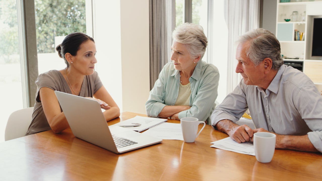 Finance, planning and senior couple discuss investment with financial advisor on a laptop at home