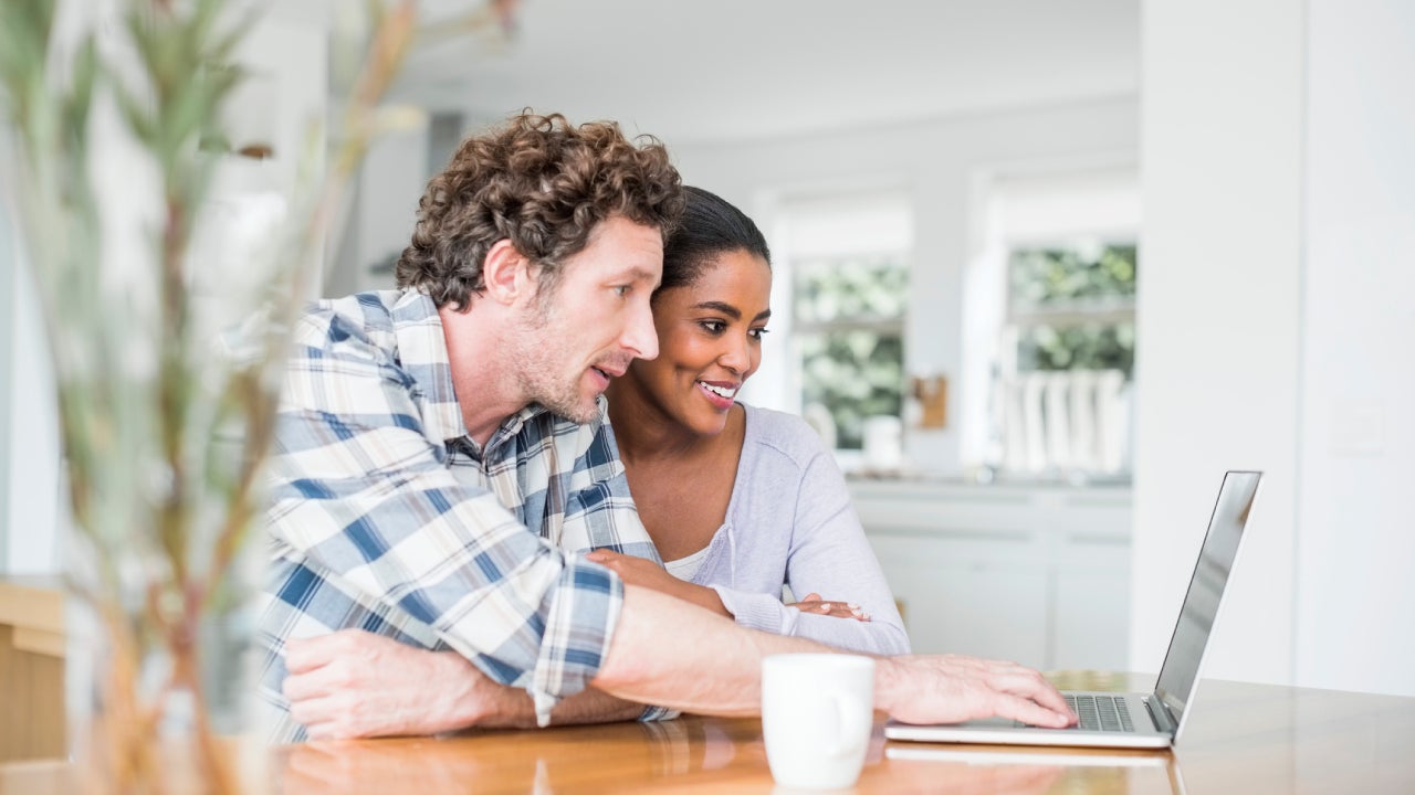 Couple using laptop at home