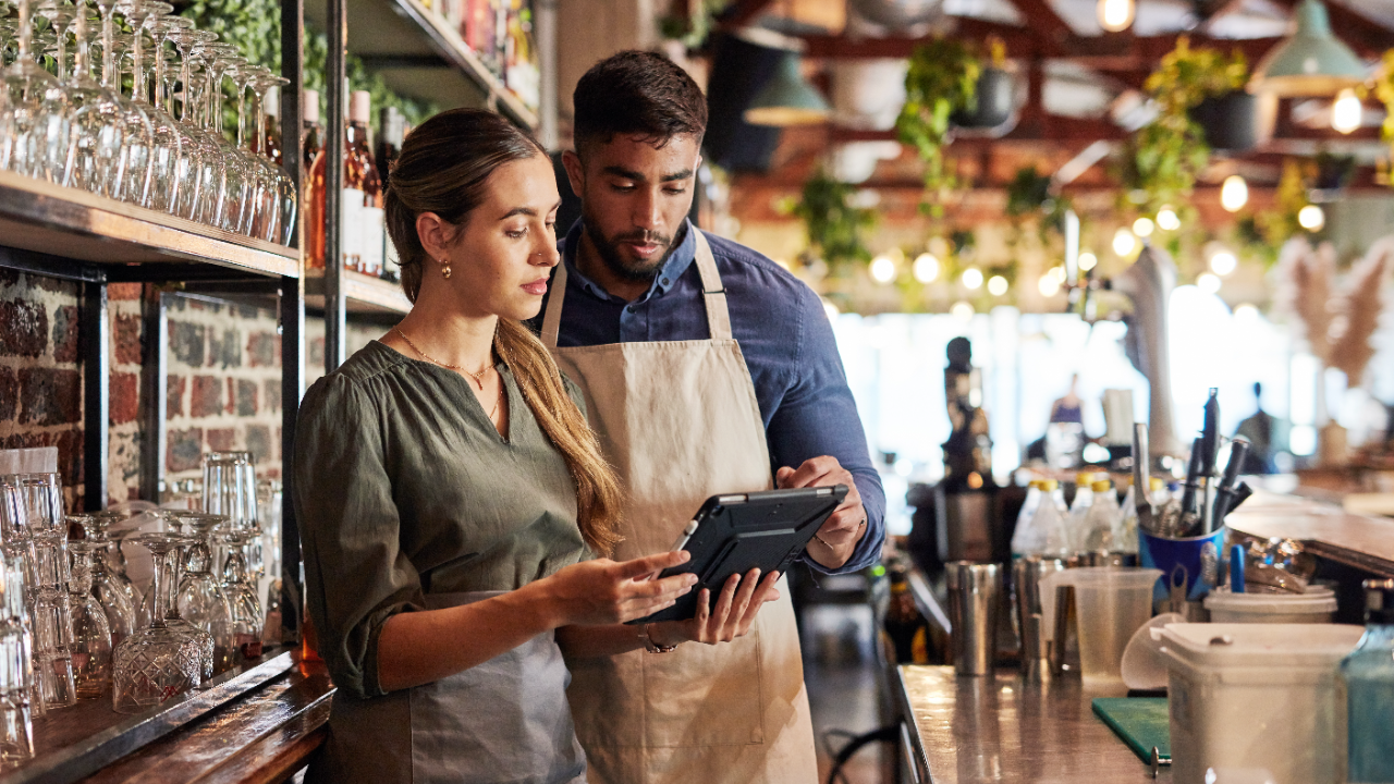 Two people review a tablet in their business