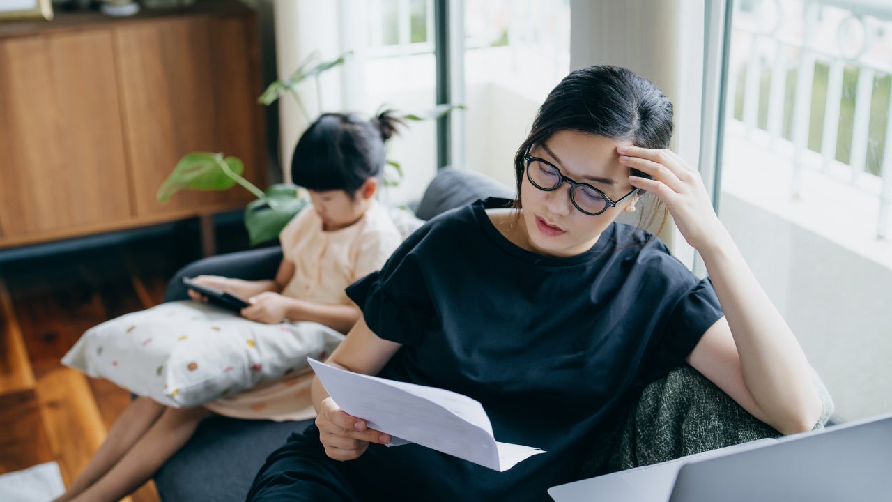 mother looking stressed while managing her financial bills