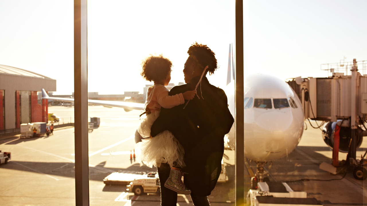 Mother holding daughter at airport