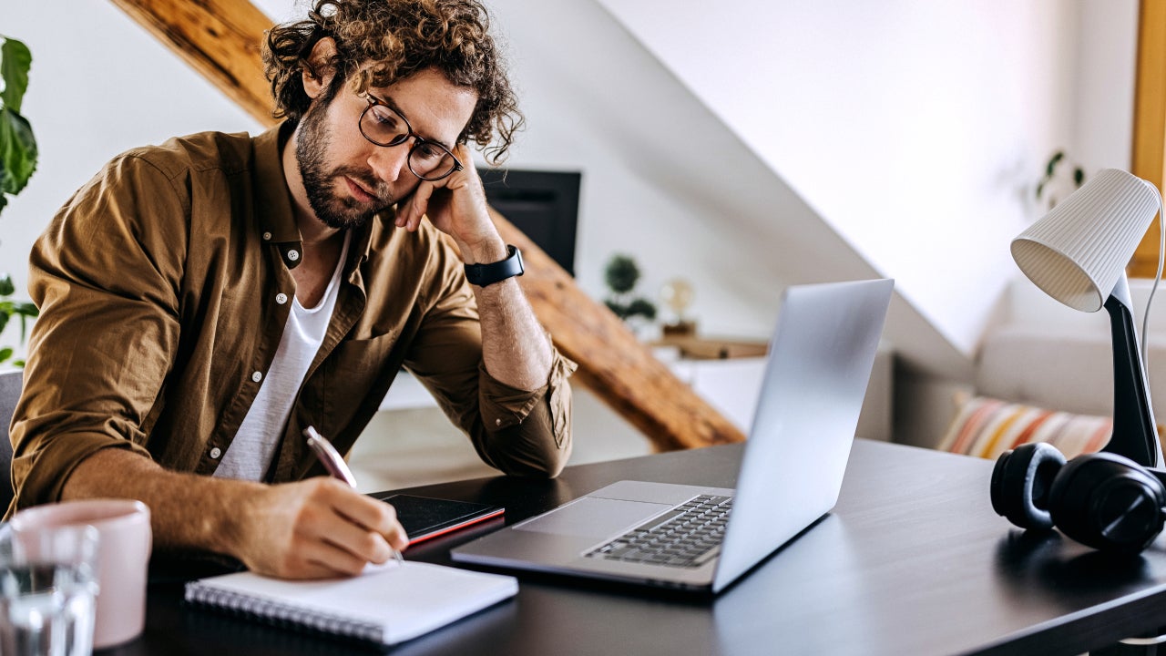 Man resting his hand on his face while reviewing documents