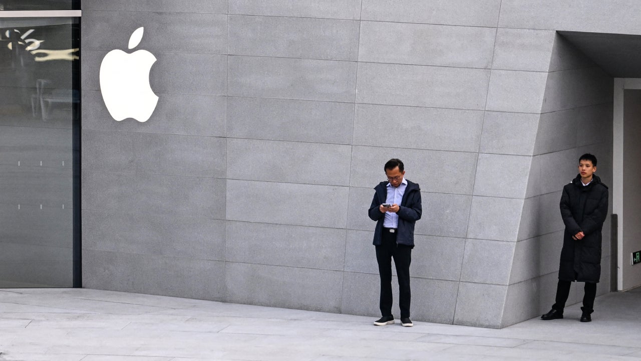 People stand outside a recently-opened Apple Store