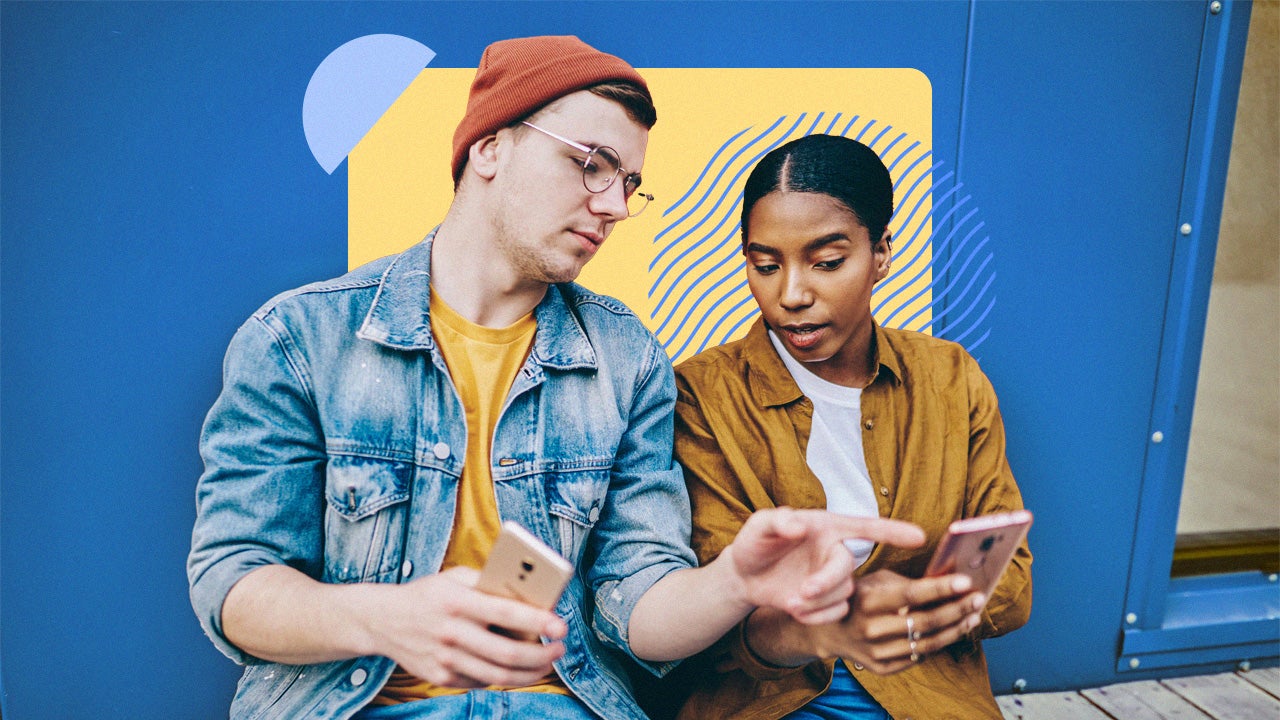 Two young adults have a conversation about something on a cellphone