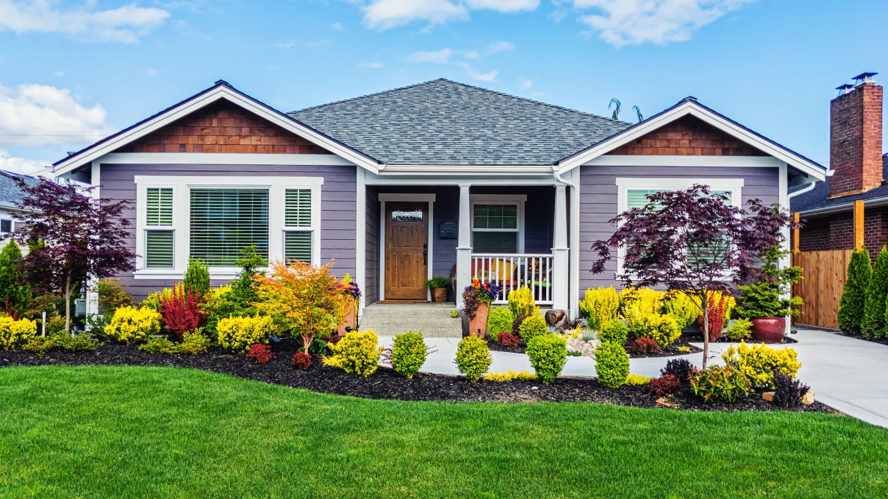 Photo of a modern custom single-level suburban home on a sunny summer day