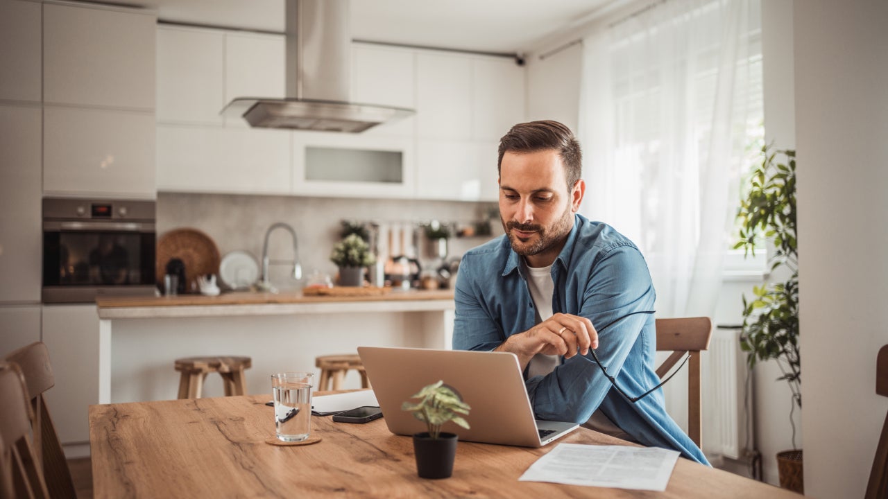 Man using laptop in kitchen