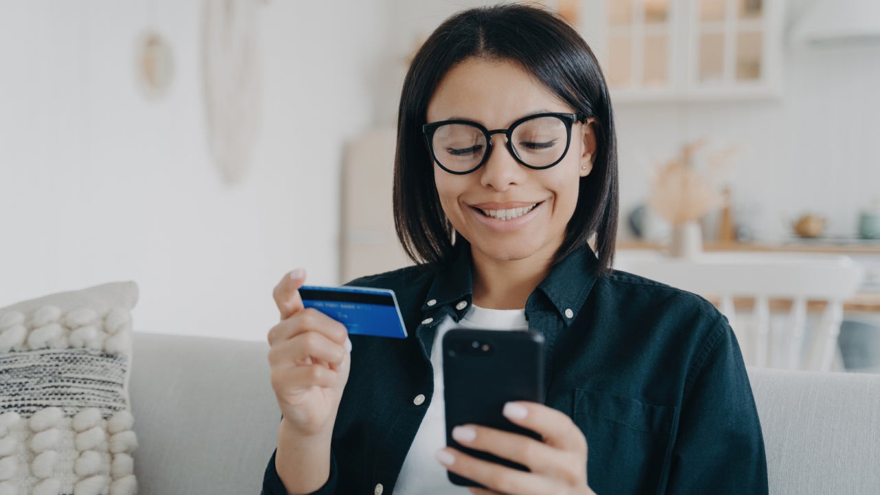 Young woman pays for purchases in online store using banking service