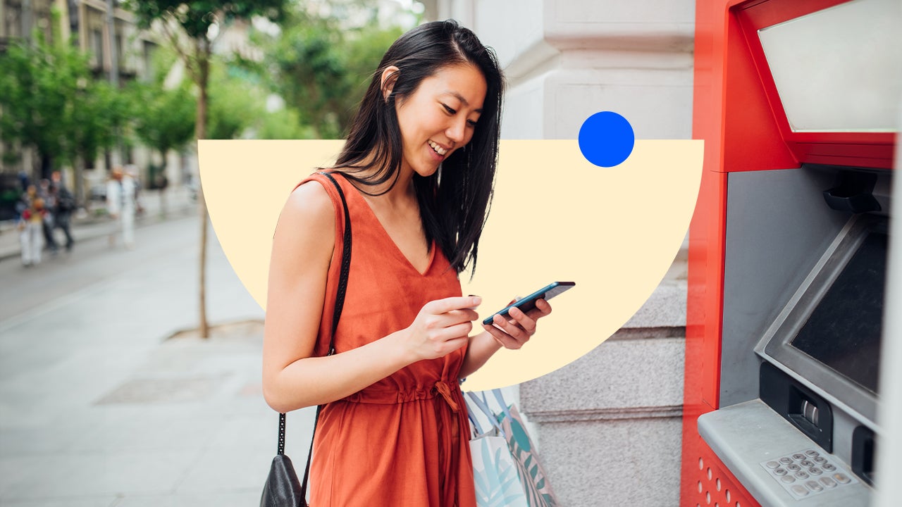 Woman using a cellphone near an ATM