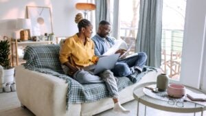 Young smiling couple working from home, going over paperwork