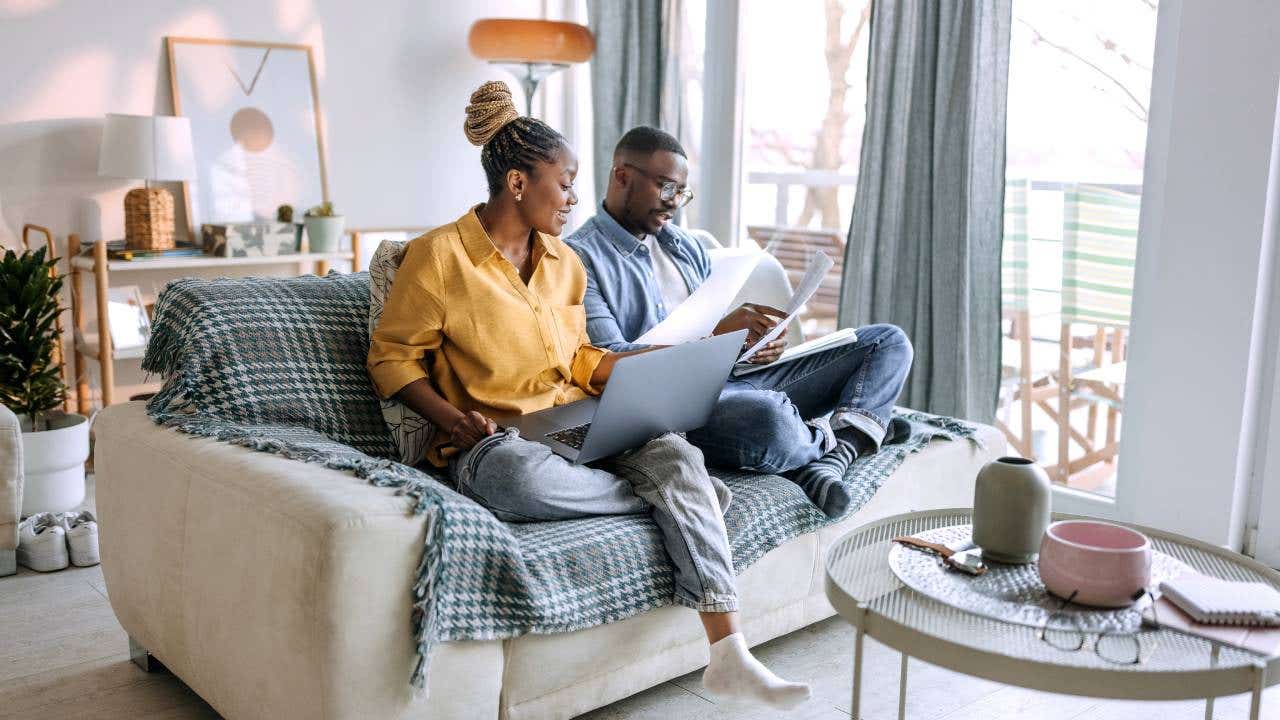 Young smiling couple working from home, going over paperwork