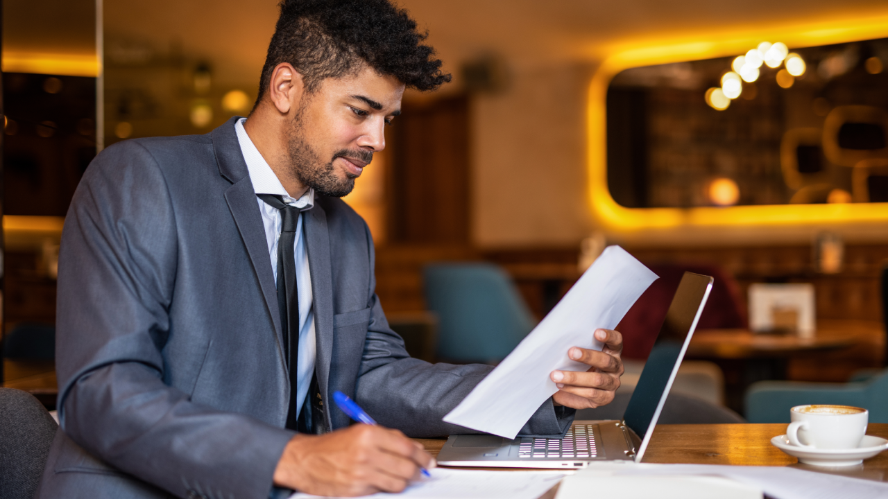 A man sits at his computer and fills out forms.