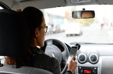 Person driving with phone in hand