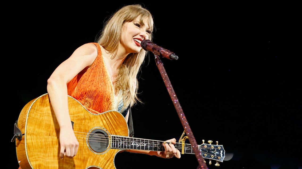 Taylor Swift performs with a guitar on the Eras Tour.