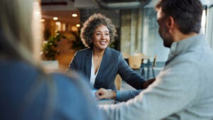 Happy banker talking to her customers in the office