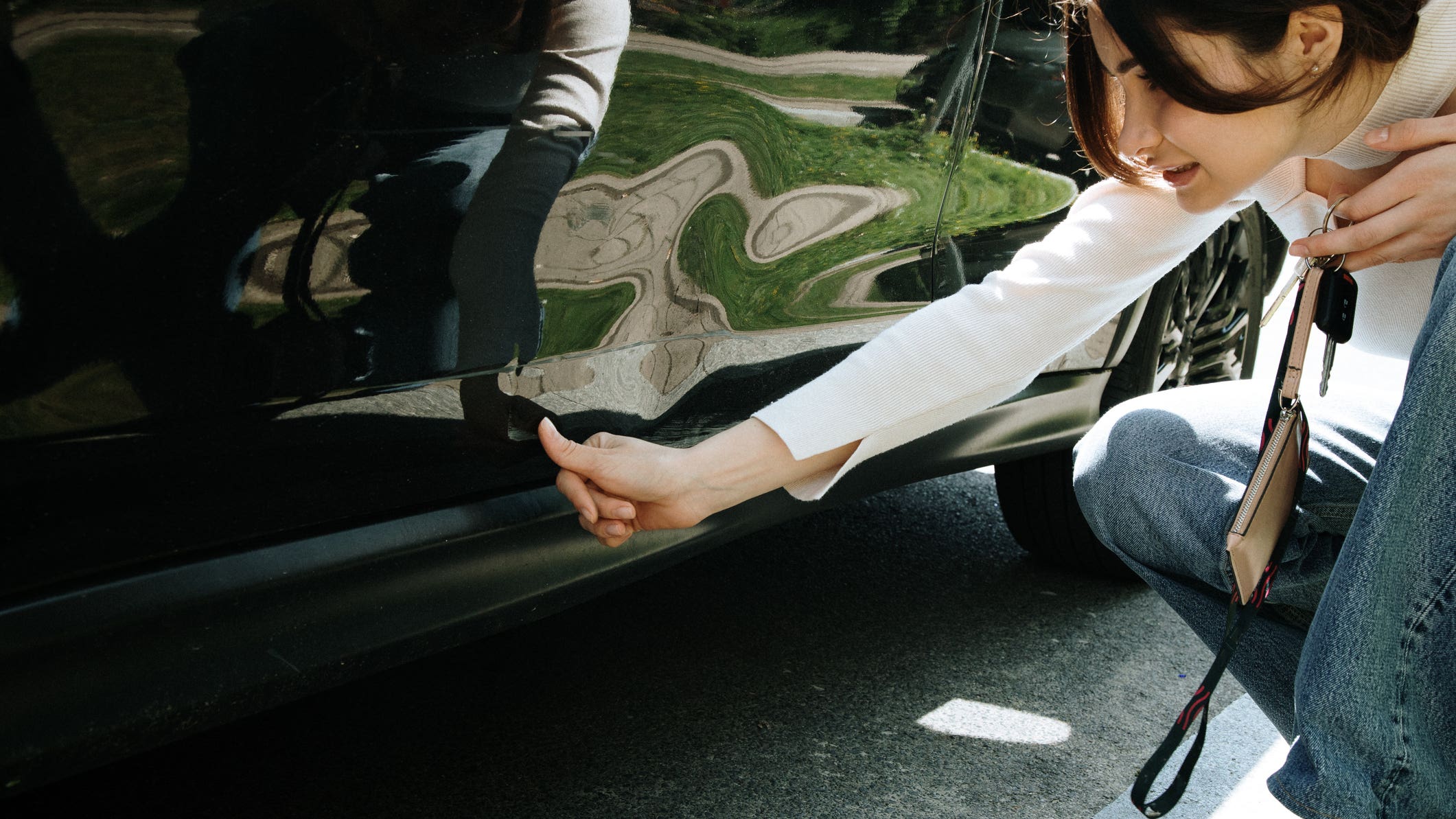 woman inspecting damage on car