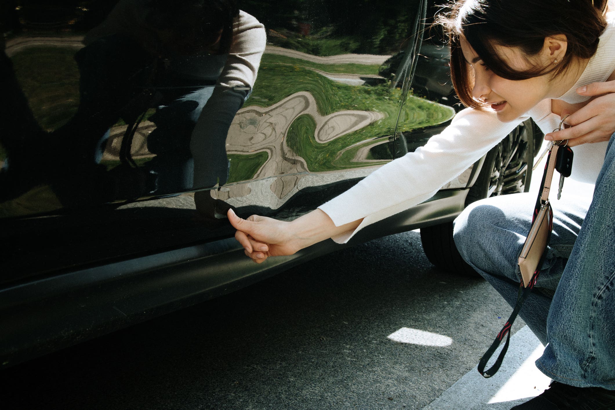 woman inspecting damage on car