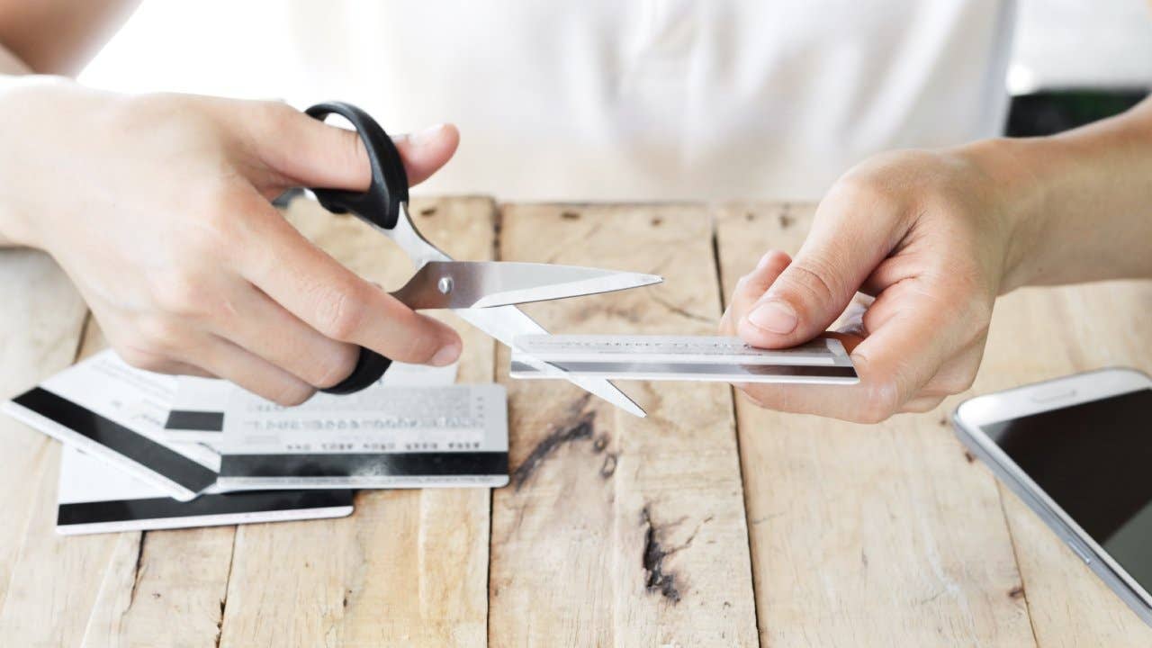 Person cutting up a credit card with scissors