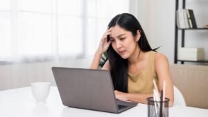 Young woman very focused on a laptop, home office