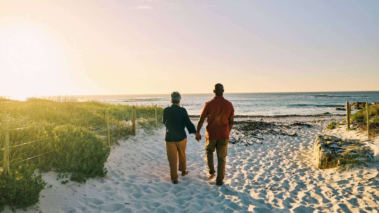 Joyful African-American couple experiencing carefree moments on coastal walk.