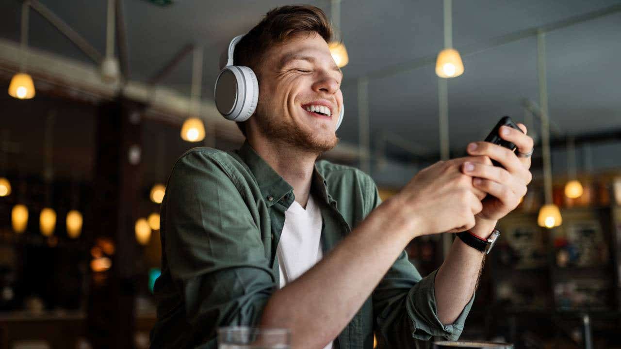 Man listening to music on smartphone at coffee shop