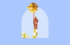 Holding up a golden piggy bank, balancing on one finger