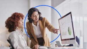 Co-workers discussing something on a computer screen