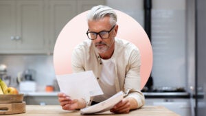 mature man reading his policy while wearing glasses