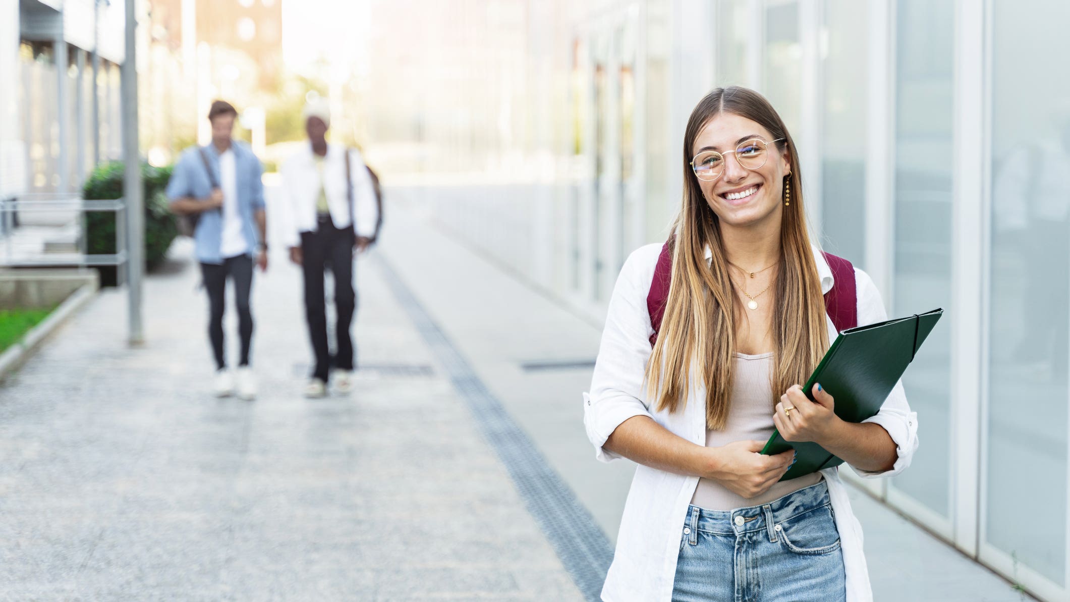 Blond college girl smiling, ready for classes at a university campus