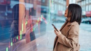 businesswoman looking at stock exchange market trading board