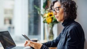 Mature businesswoman looking at her phone at a cafe.