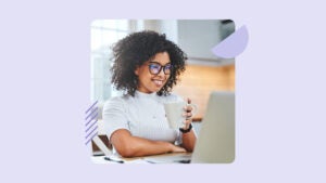 A black woman looks at her laptop.