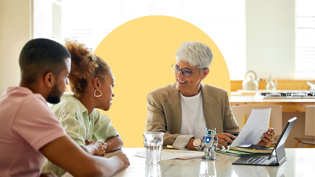 A couple talks with a financial advisor at a conference table.