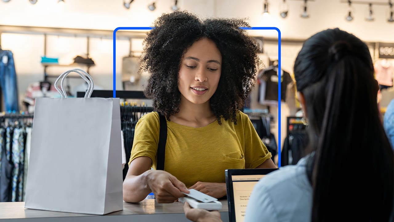 Woman paying for merchandise at store with credit card