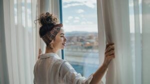 Woman looking out the window at scenic view below.