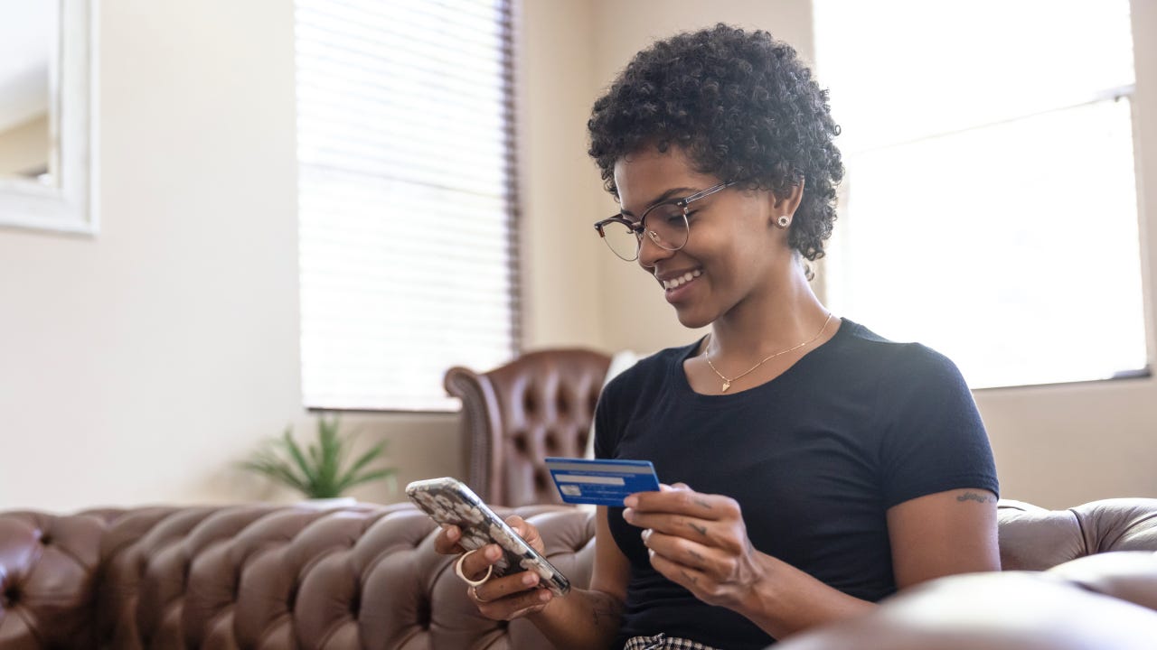 A young woman paying using her credit card on her phone